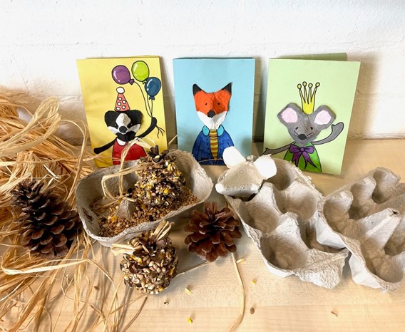 Empty egg cartons and cards with badger, fox, and mouse faces made from egg carton parts