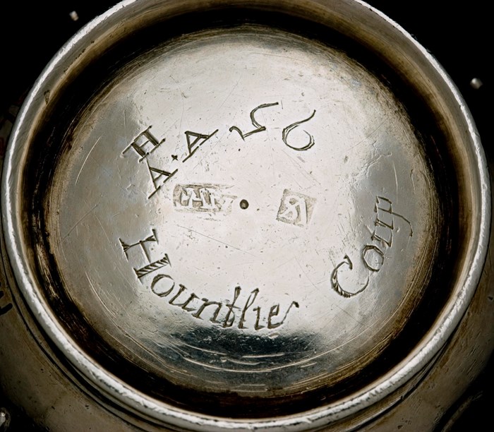 Closeup of the bottom of the thistle cup, revealing a circular engraving which reads: 'H A+A Hountlie Coup 95' and a faint assay mark.