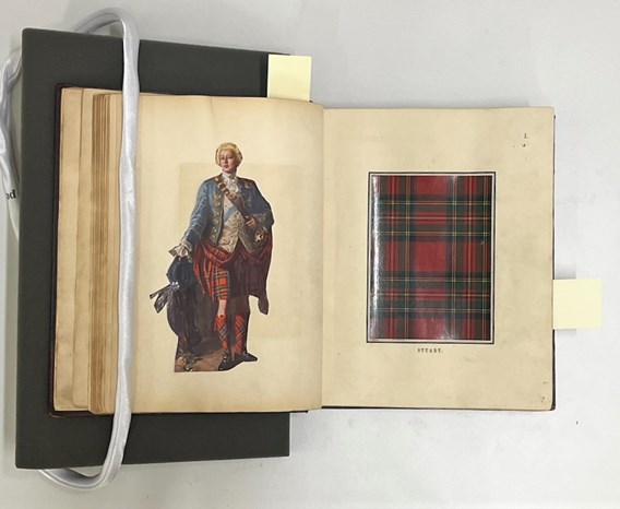 An open book, weathered and yellowed with time, shows a swatch of red and green tartan on the right page, and an aristocratic figure in a blue jacket and the same red-green tartan on the left.