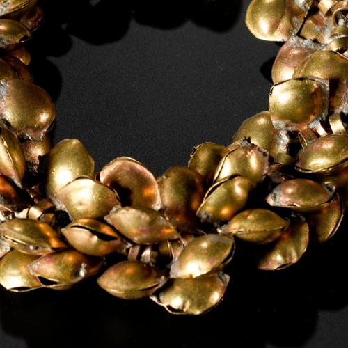 Anklet of gilded copper pellet bells, threaded onto string.