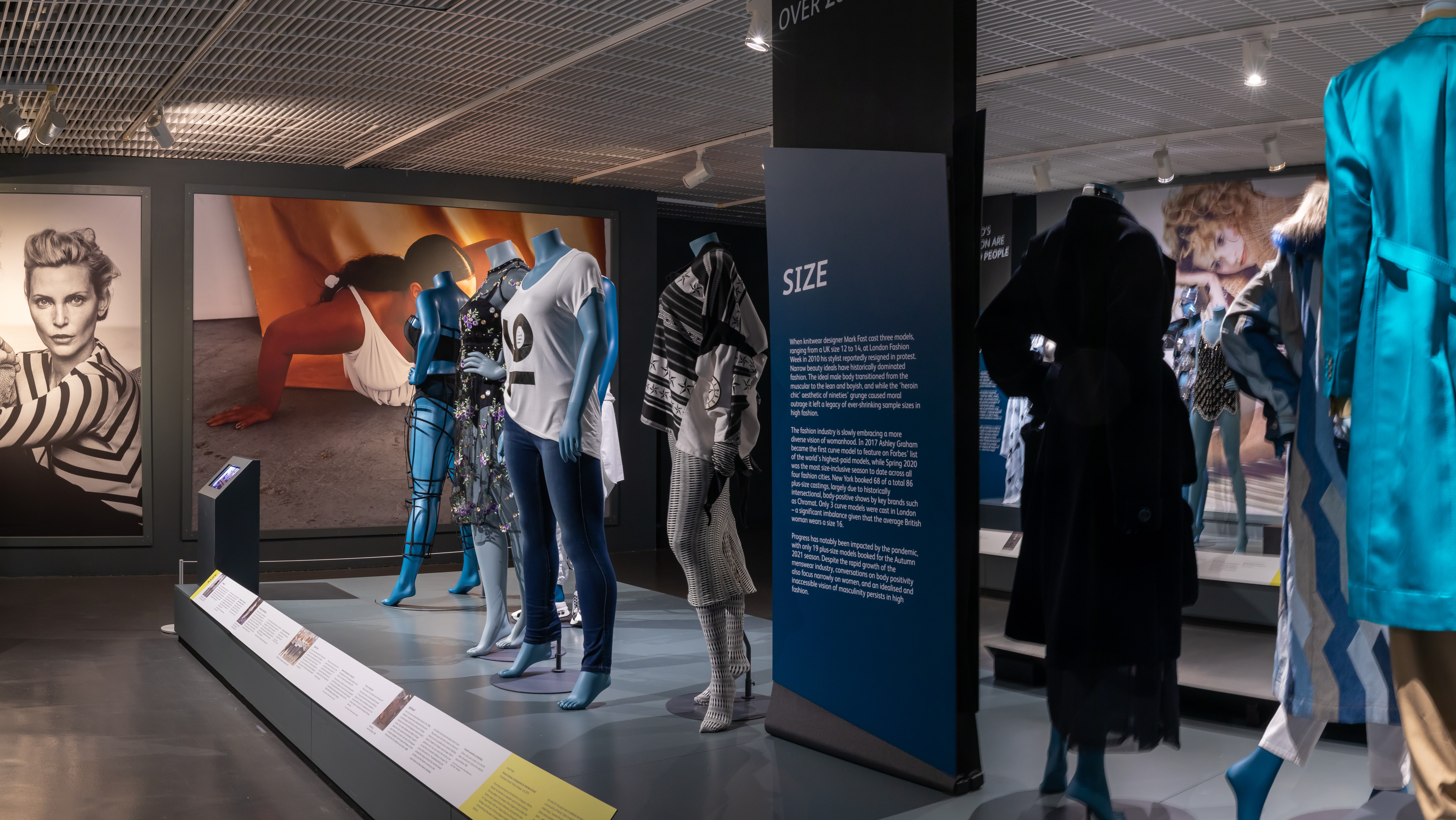 Ten mannequins arranged across the exhibition with photographic backdrops.