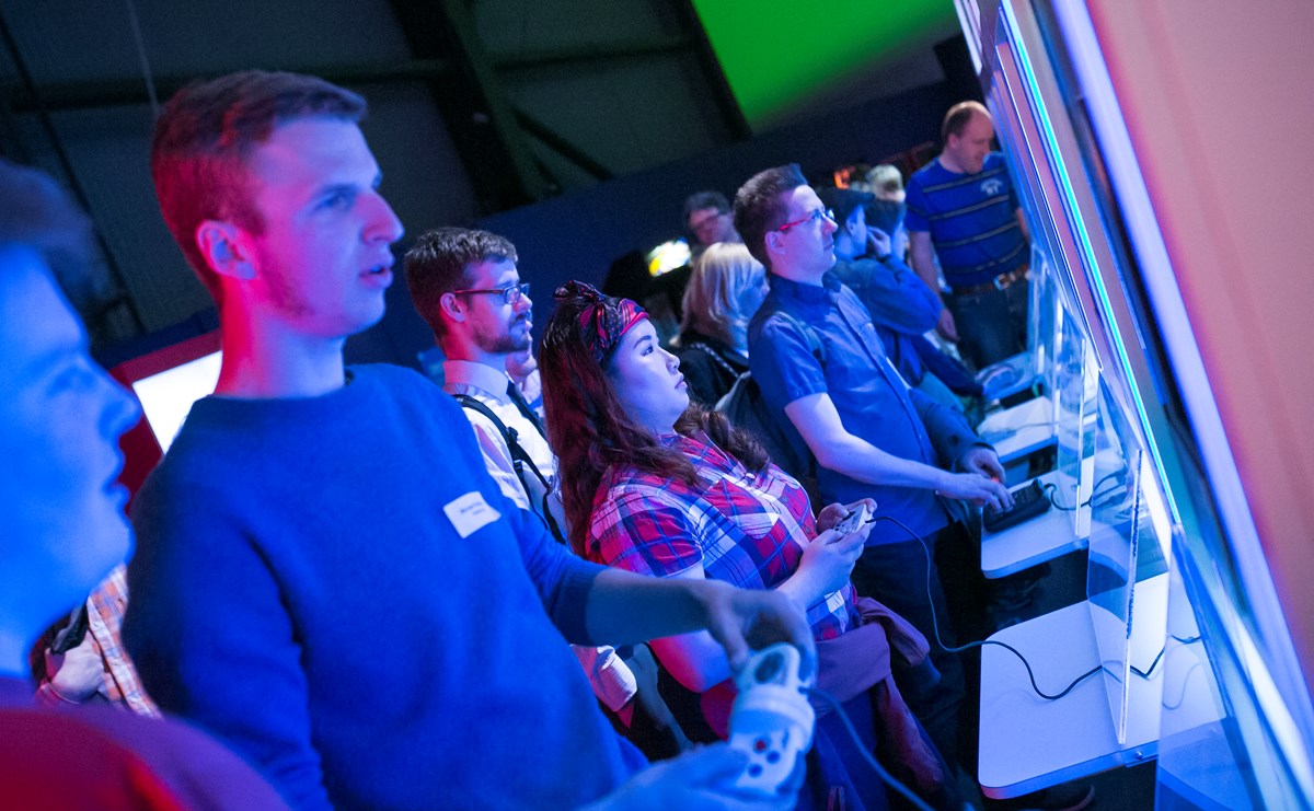 Nine players line up to play across a number of static consoles in a Game On exhibition space at Life in Newcastle.