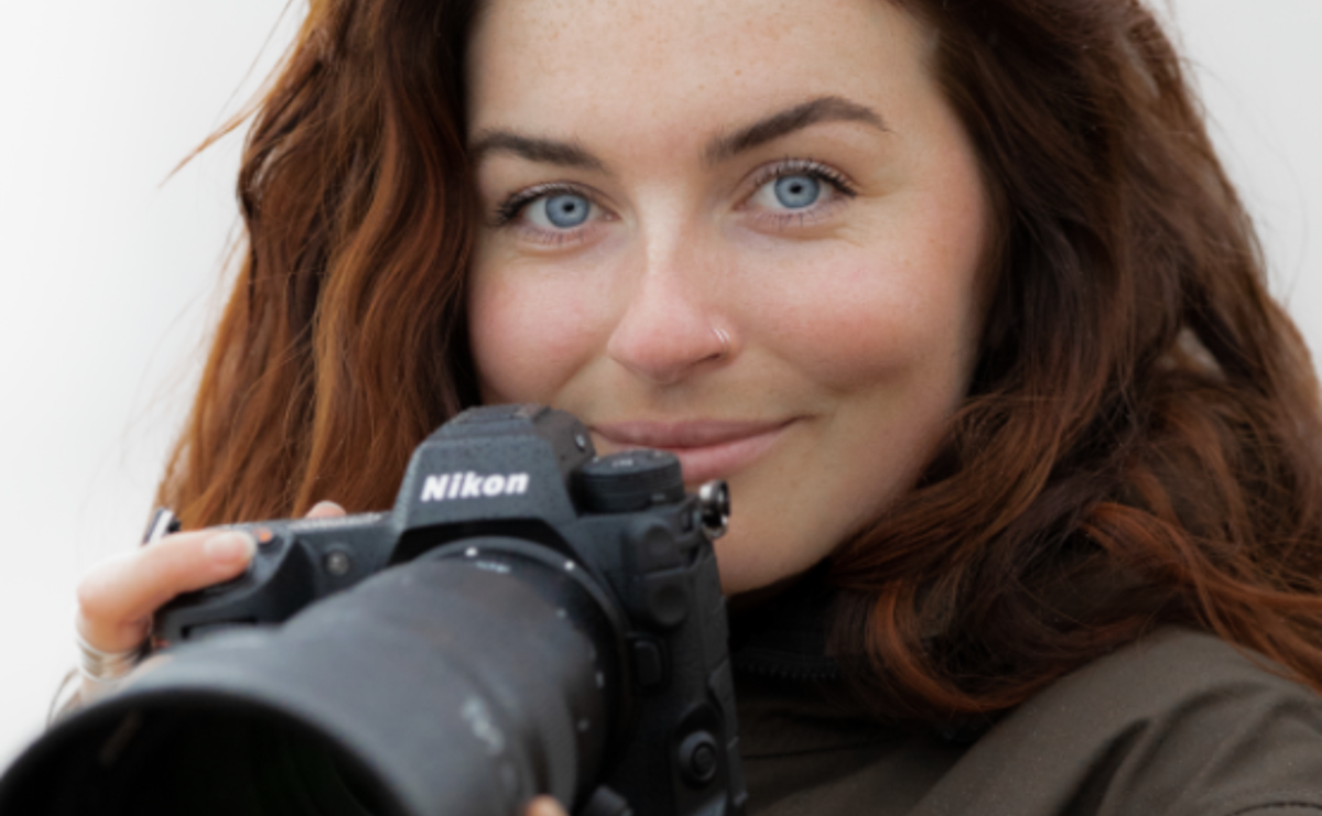 A person holding a camera and smiling