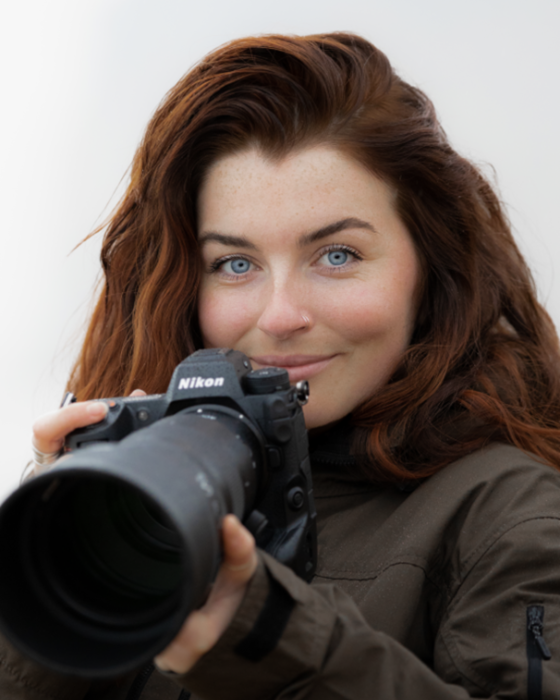 Rachel Bigsby holds a camera with a long lens.