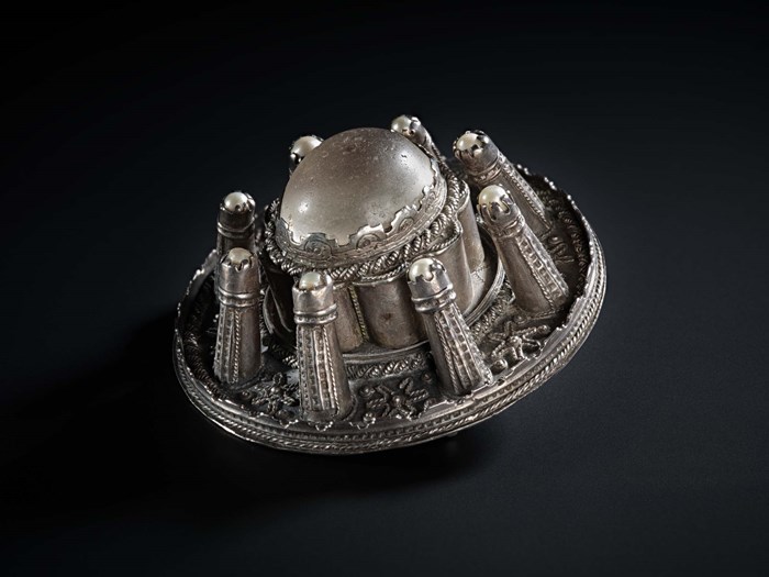 The side view of a silver brooch.