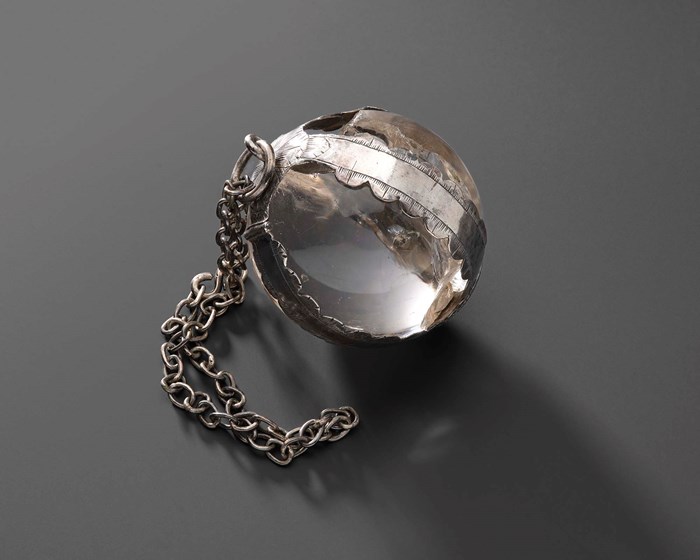 A crystal rock on encased in silver with a chain attached.
