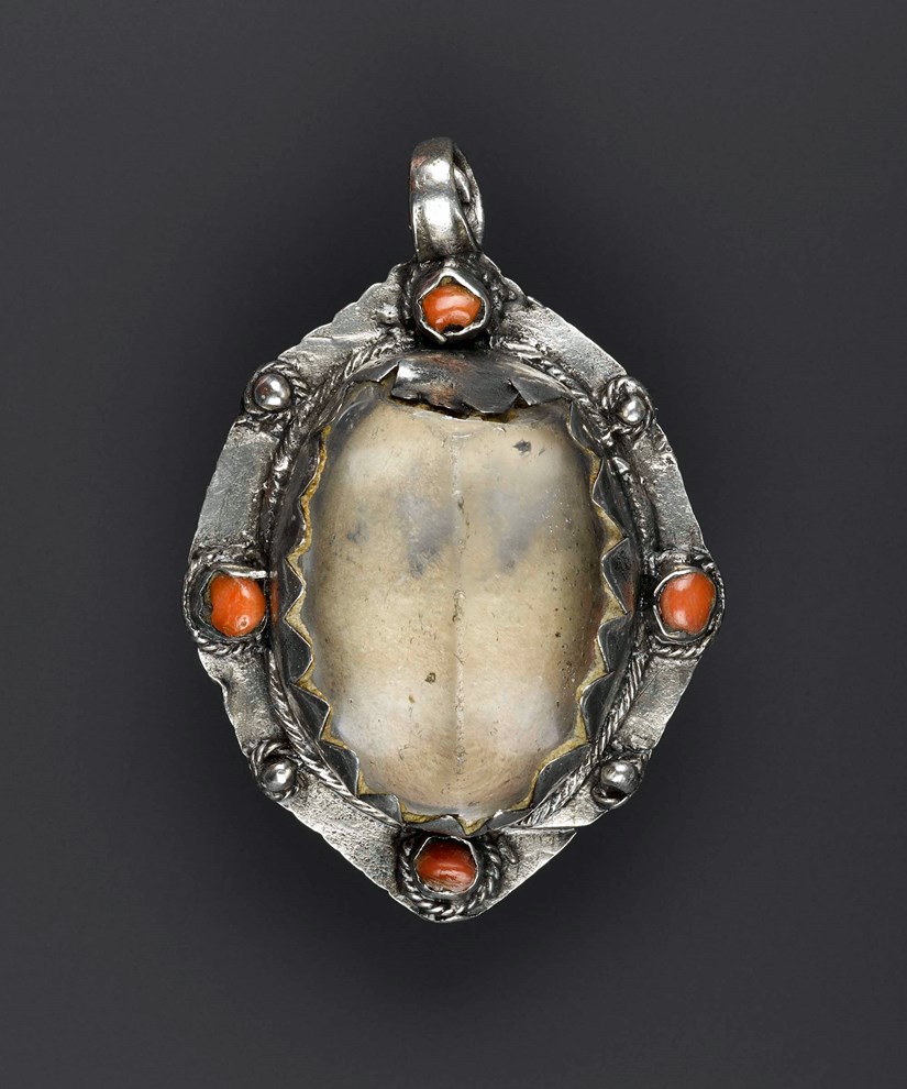 An oval shaped pendant with a crystal centre and jewels on the outer edge.