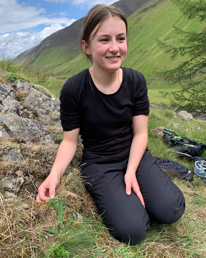 Portrait of Holly Doherty sitting on a hillside