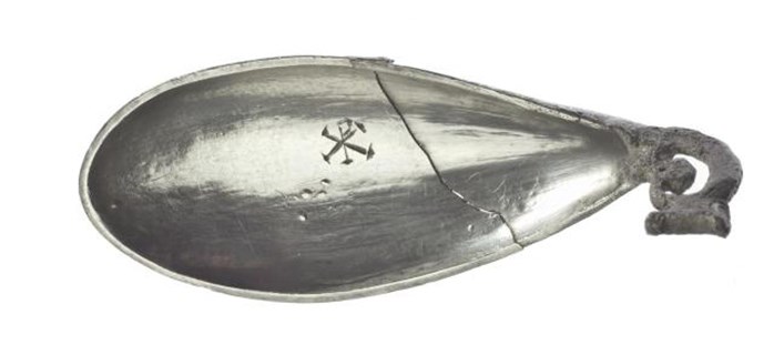 Silver spoon without handle, decorated with an Chi Rho symbol that looks like an X and P combined.