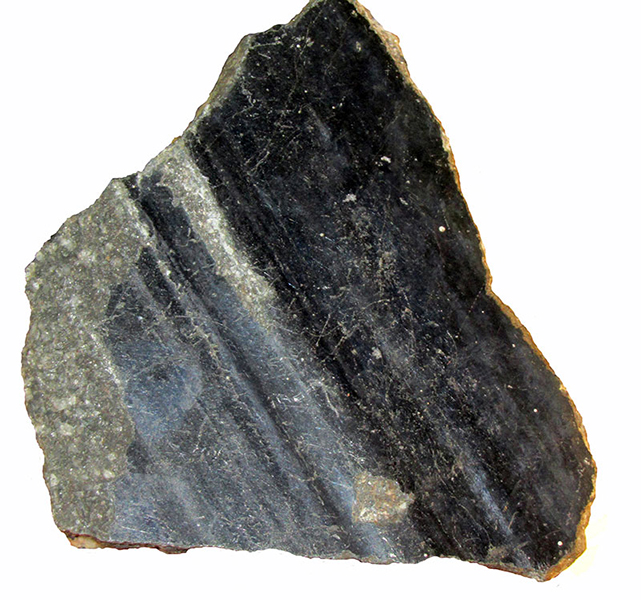 Galena with slickensides, from Alston, Cumberland, England. Slickensides are smooth scours that form on a fault surface after one side has been dragged past the other side during an earthquake. They usually develop on rock faces but in this case they form an undulating surface across a single large mineral called Galena - a lead sulphide.