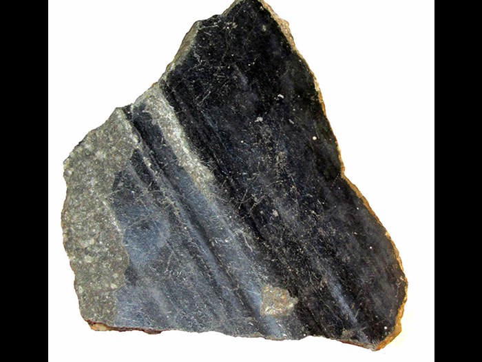 Galena with slickensides, from Alston, Cumberland, England. Slickensides are smooth scours that form on a fault surface after one side has been dragged past the other side during an earthquake. They usually develop on rock faces but in this case they form an undulating surface across a single large mineral called Galena - a lead sulphide.