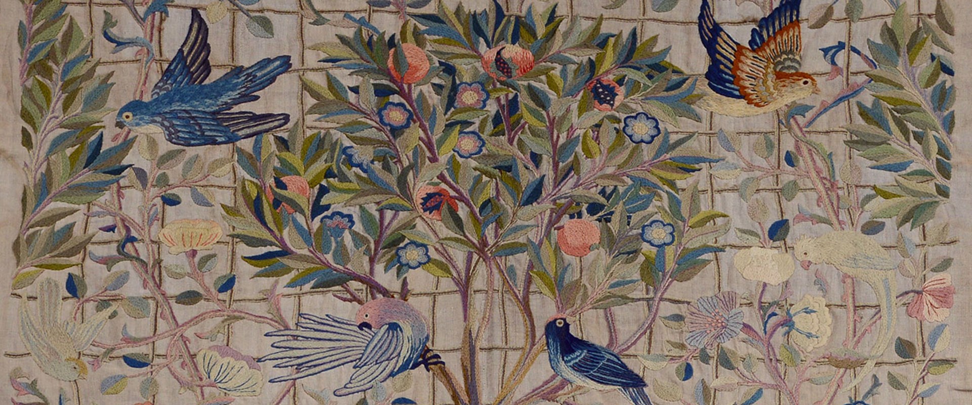 Embroidery of a group of colourful birds perching on a tree and branches.