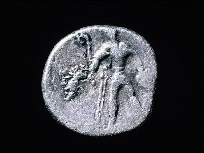 Gaulish coin showing a warrior carrying a carnyx, boar standard and severed head.