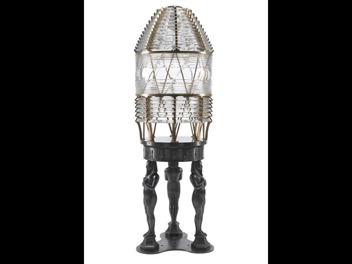 Model of a first order dioptric fixed light. It stands on an elaborate pedestal of cast bronze Egyptian figures and is a work of art in its own right.