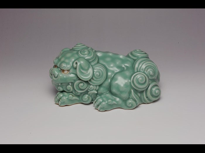 Sculpture of recumbent lion-dog (shishi) with celadon glaze, by Makuzu Kozan I, 1900-10.