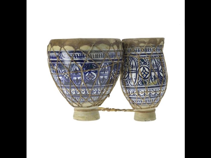 This tbilat or double drum is earthenware with a white tin oxide glaze, and painted in blue with bands of stylised foliage.