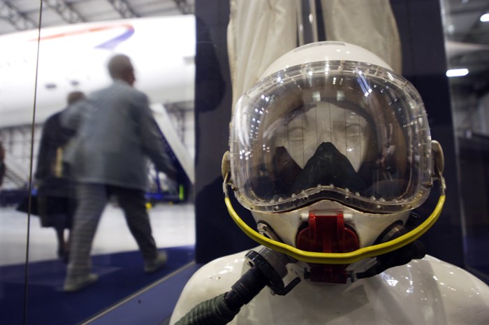 A mannequin seated in a plane wearing a pilot's helmet.