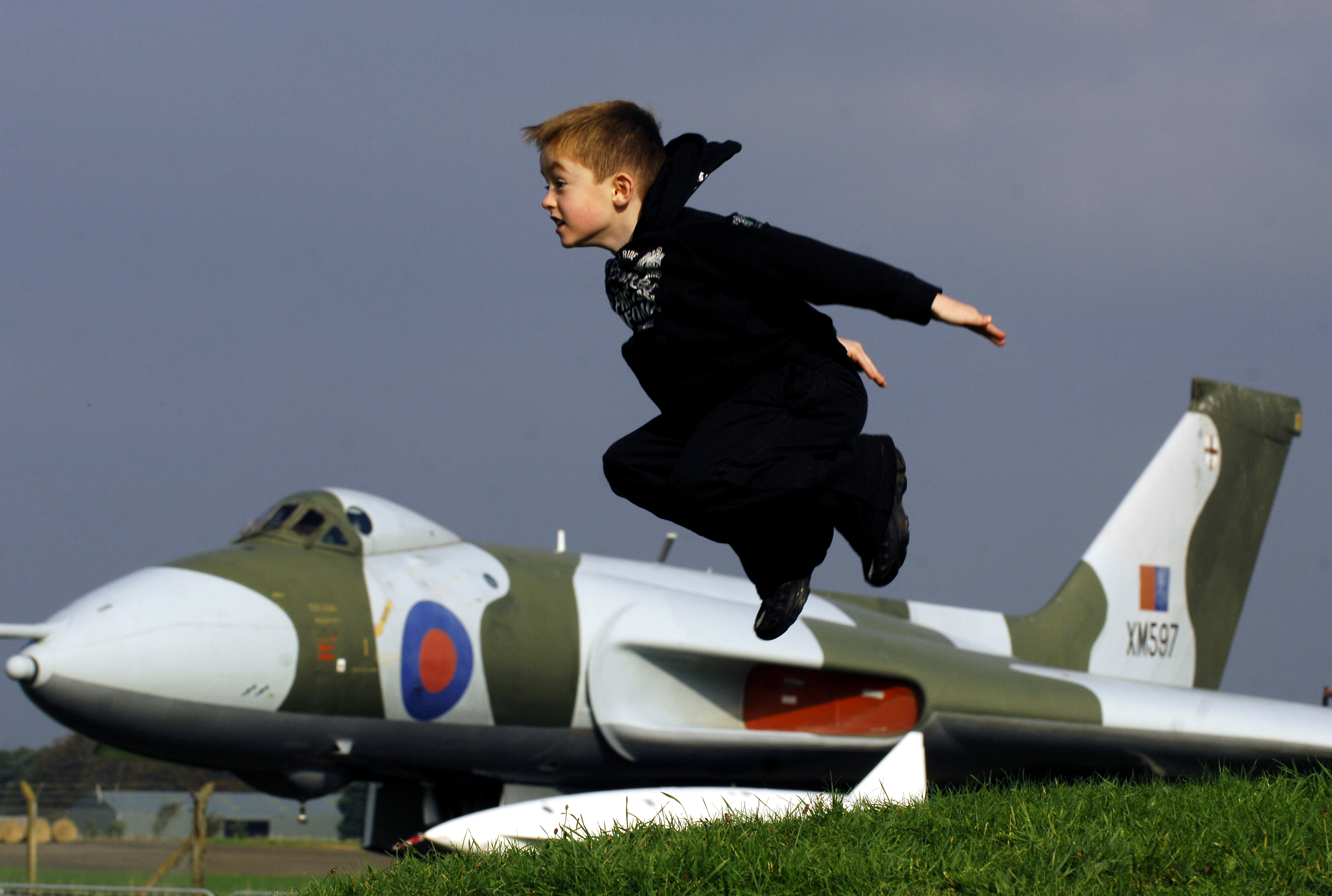 Boy taking flight from bunker in view of Avro Vulcan XM597 at National Museum of Flight, East Fortune Airfield.