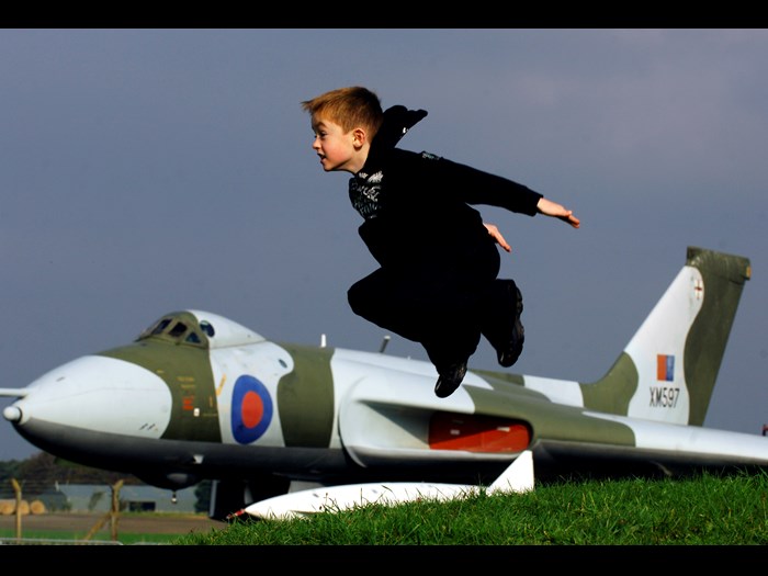 Boy taking flight from bunker in view of Avro Vulcan XM597 at National Museum of Flight, East Fortune Airfield.