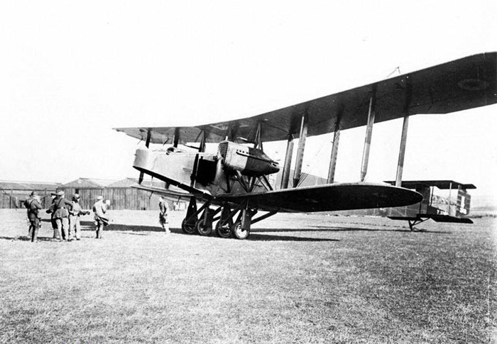 A group of six people standing in front of a large aircraft in a grassy field at East Fortune.