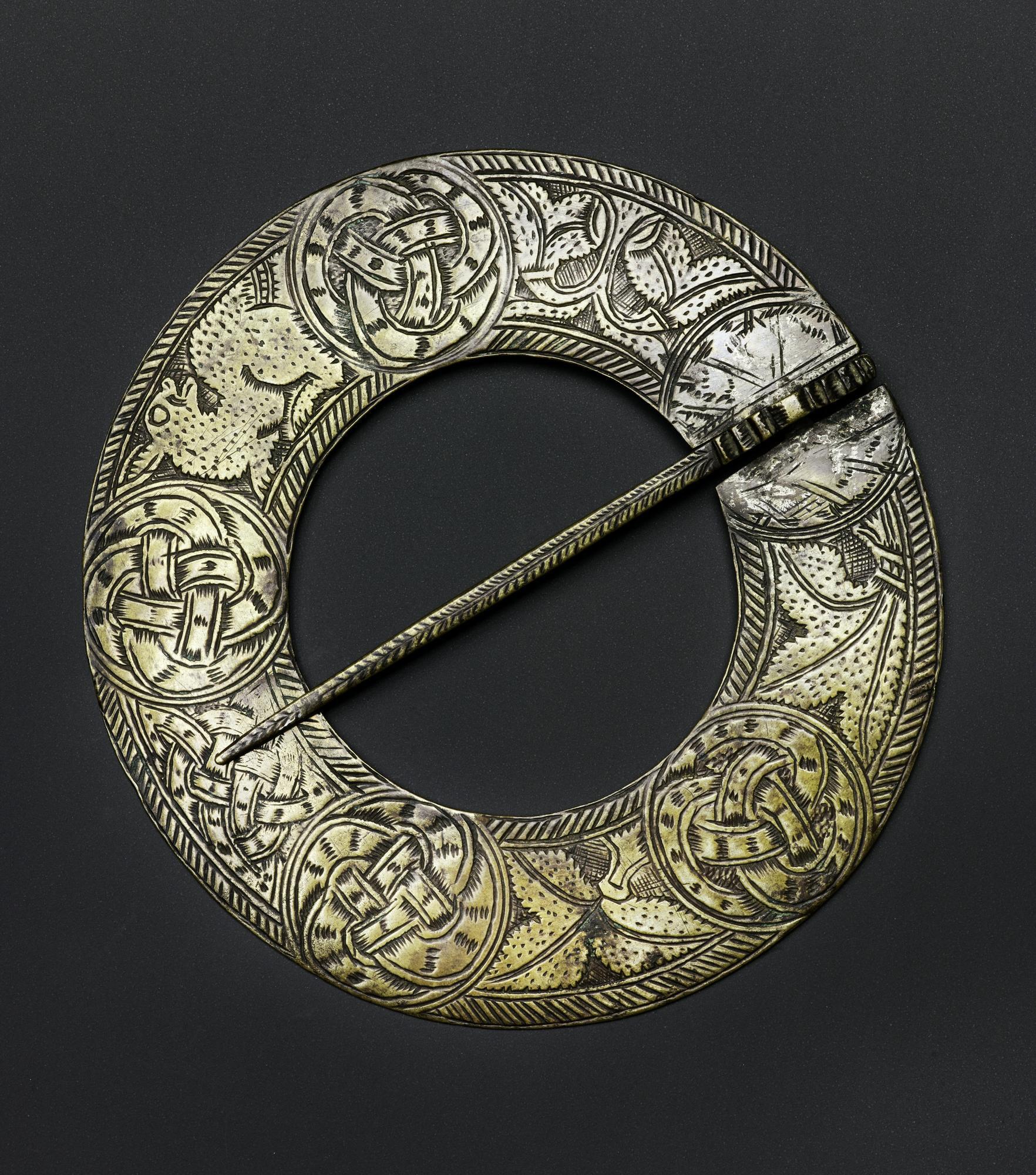 Image of Circular brooch of brass, ornamented with five circular panels, four having interlaced work and one a leaf design, from Leochel Cushnie, Aberdeenshire © National Museums Scotland