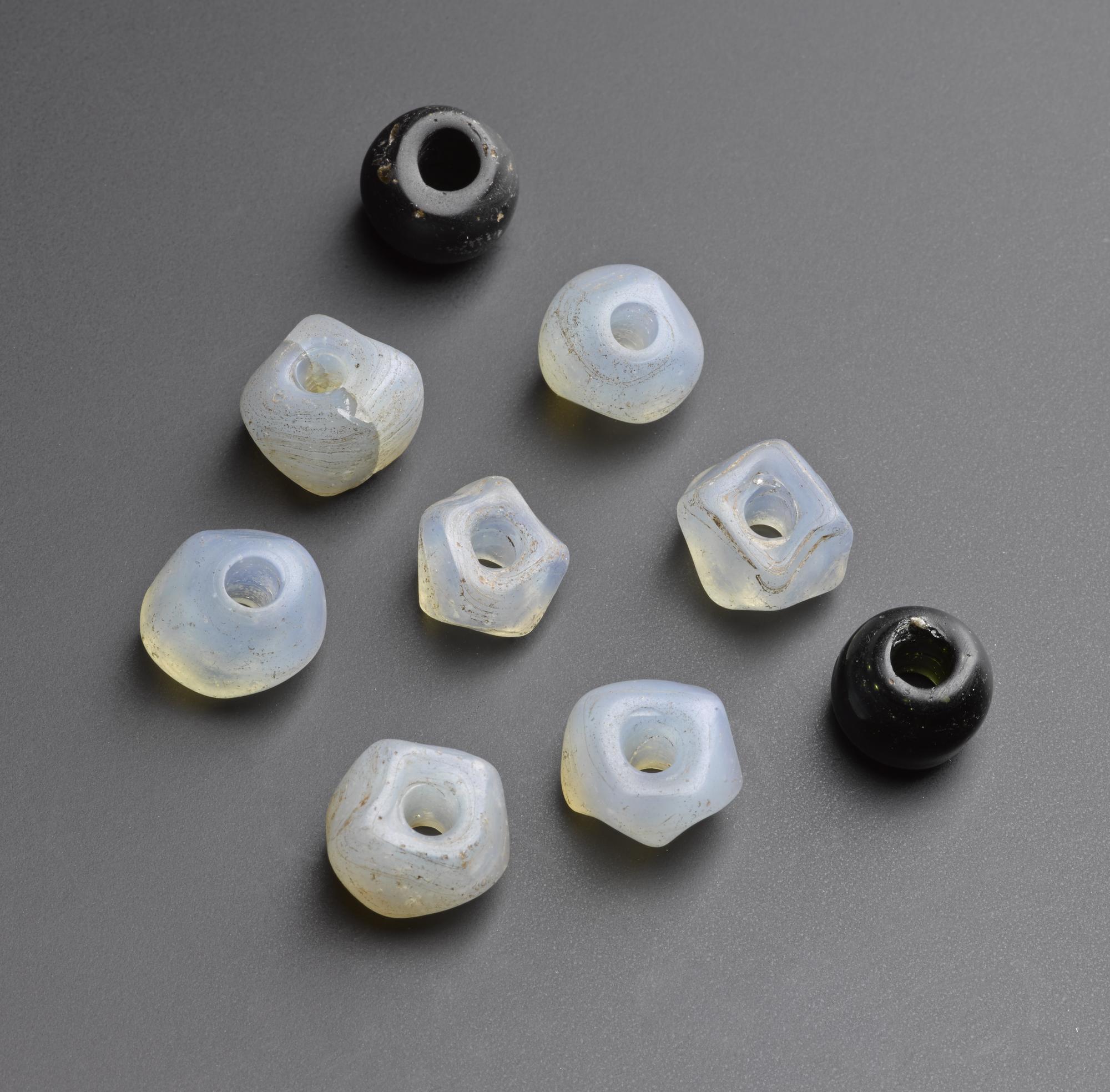 Image of Seven opalescent faced beads and two black oval beads of post-medieval date, from Morham, East Lothian © National Museums Scotland
