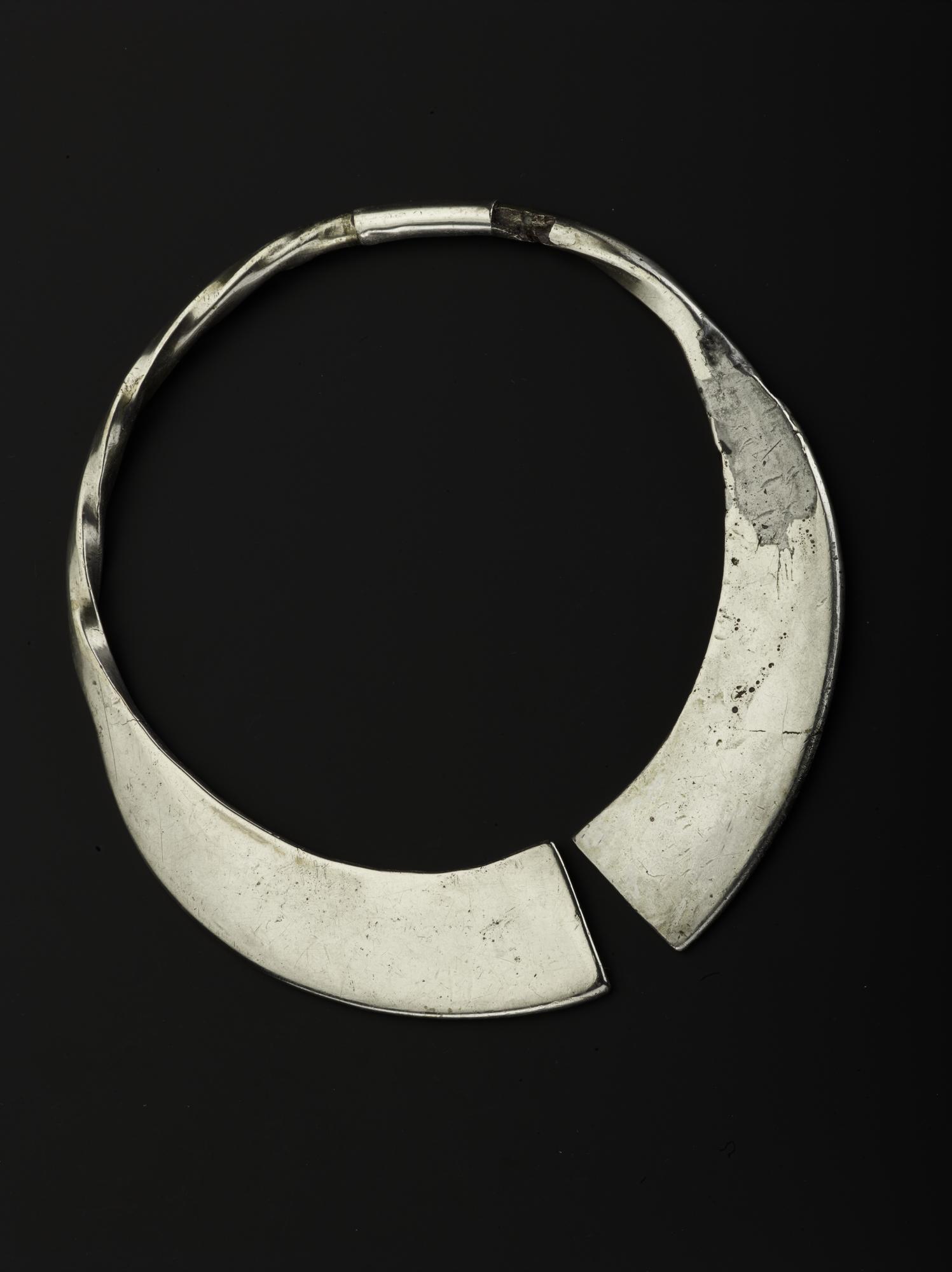 Image of Incomplete silver penannular brooch, pin missing, with plain terminals and twisted hoop, now broken into two pieces joined by a repair sleeve, from Norrie