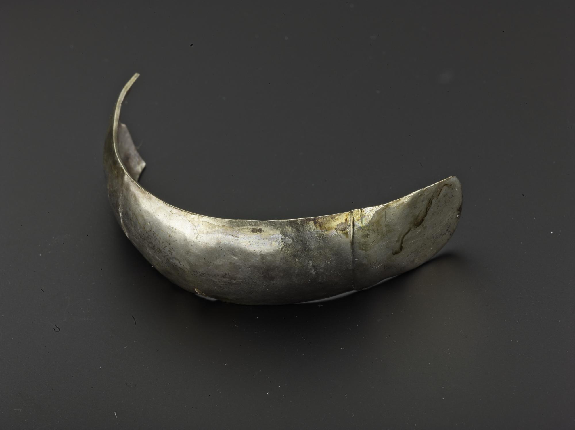 Image of Fragment of silver bangle with undecorated sub-circular terminal, from Norrie