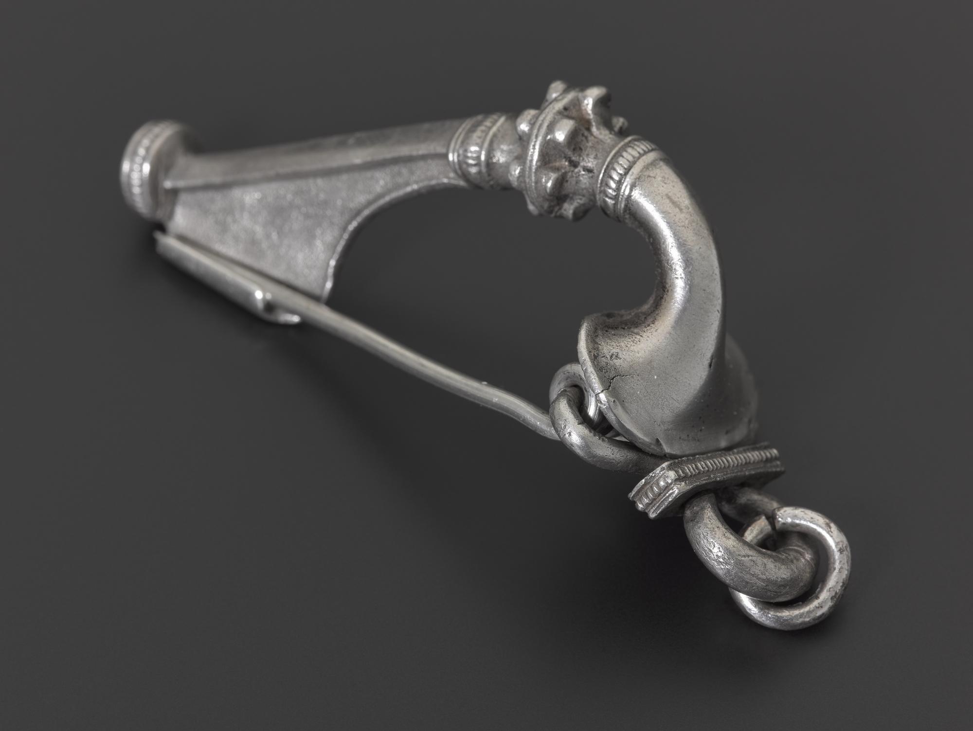Image of Brooch, also known as a fibula, of silver, it is of a special type called a trumpet brooch, this is due to the shape of the head which protects the spring, it could have been worn as a pair, linked to its partner by a chain, from Ayrshire, Roman, 80 - 180 AD © National Museums Scotland