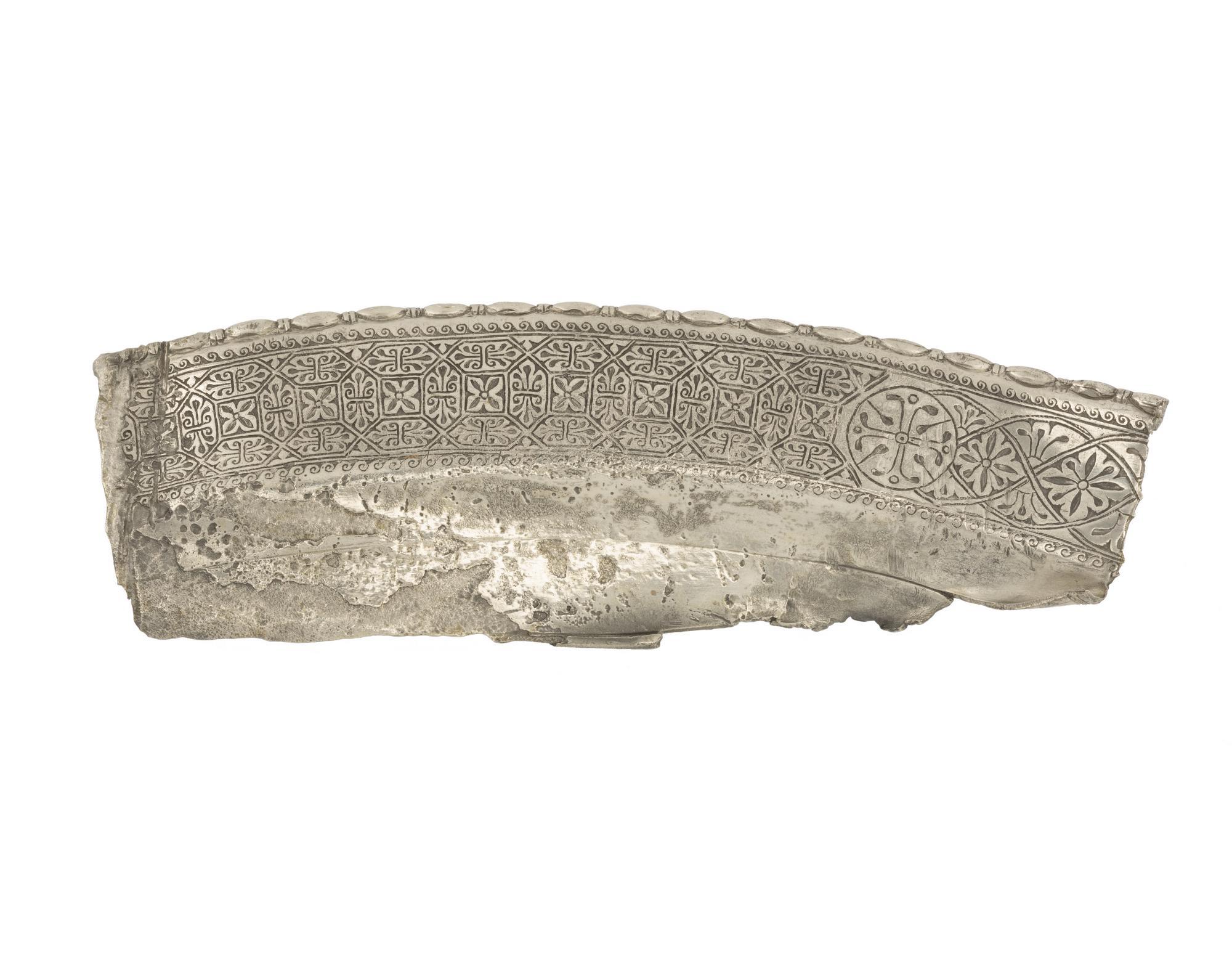 Image of Edge fragment of a flat silver plate with edging of oblong beads and small discs and with niello patterns, from Traprain Law, 410 - 425 AD © National Museums Scotland