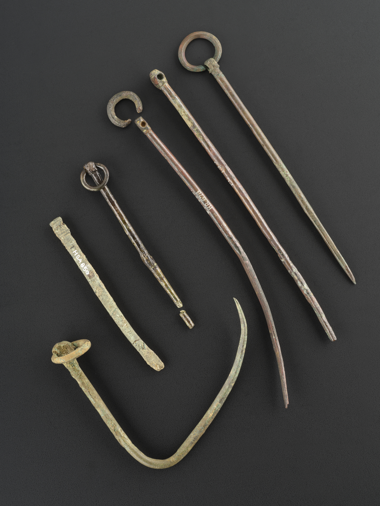 Image of Plain-ringed, polyhedral-headed type, copper alloy pin with decorated head and shank, the upper portion is round-sectioned and the lower portion sub-rectangular in section, the shank curves back very sharply into a hook, from Machrins, Colonsay, Argyll © National Museums Scotland