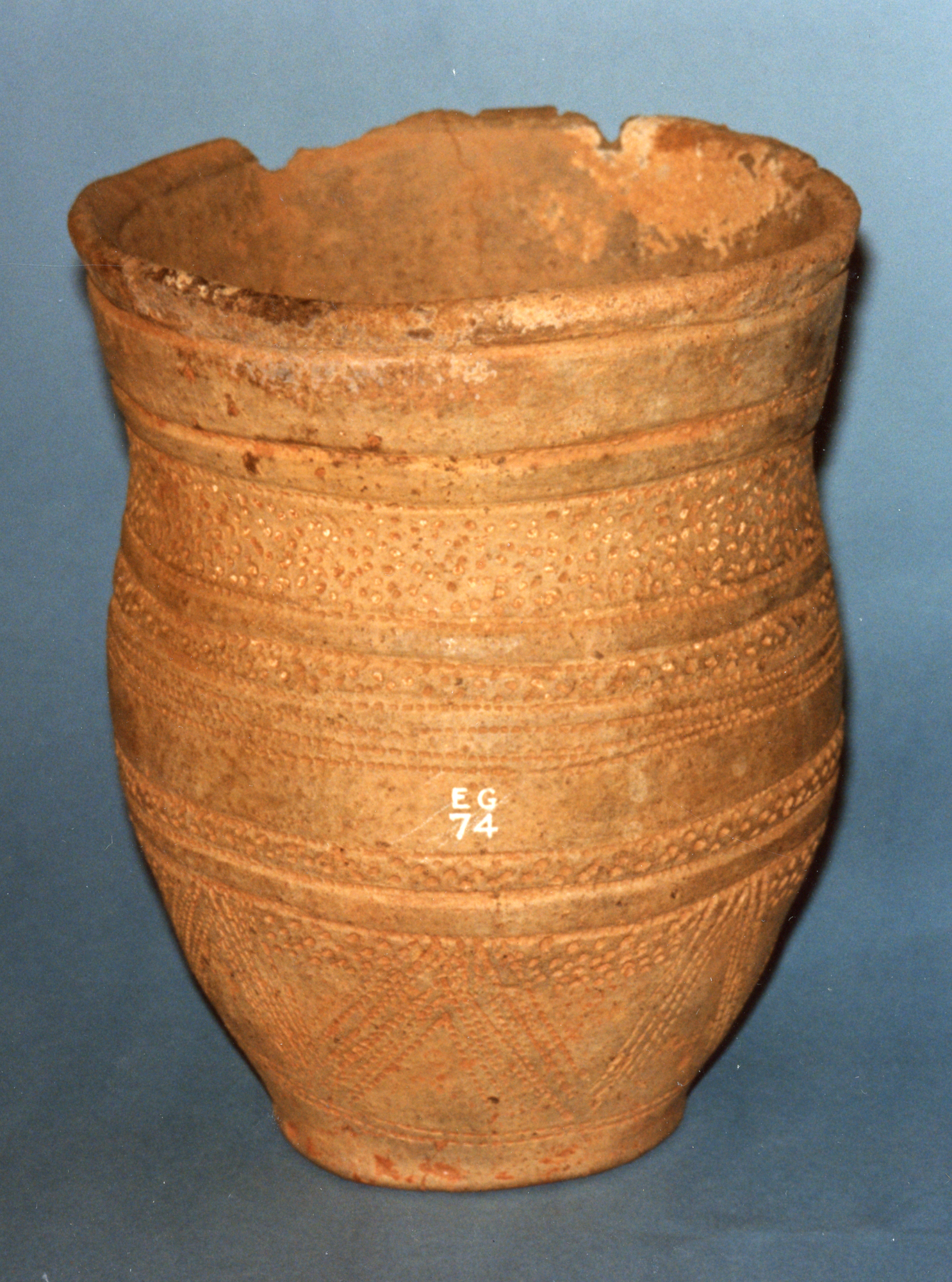 Image of Full sized beaker of light brown clay from a smaller than normal cist with the cremation of a 3 - 5 year old child, from Thornton, Innerwick, 2300 - 1800 BC © National Museums Scotland