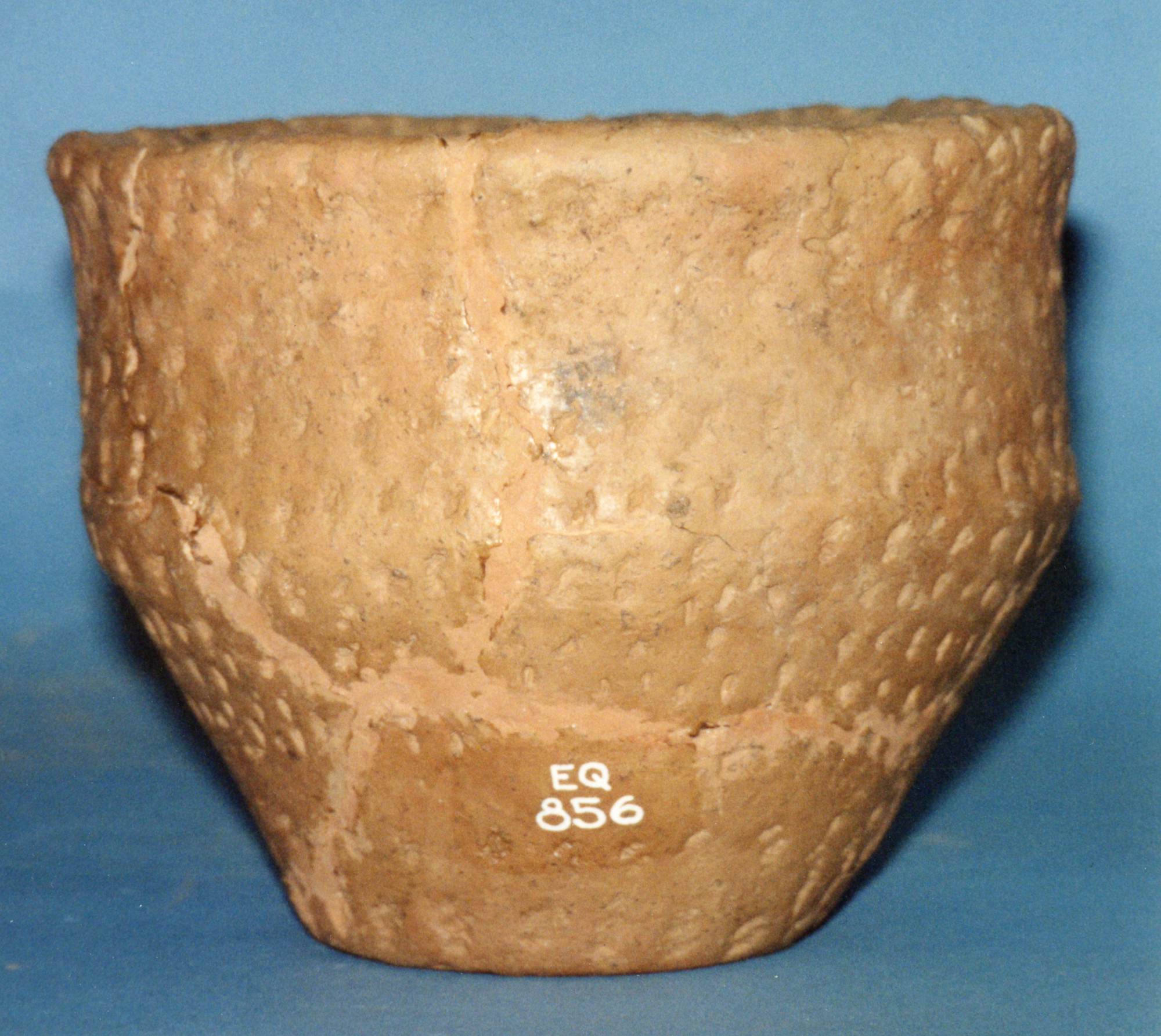 Image of Vase-shaped food vessel of reddish clay decorated with horizontal lines of small vertical jabs made with two different implements, complete but restored from fragments, from a cist at Almondbank, Perthshire © National Museums Scotland