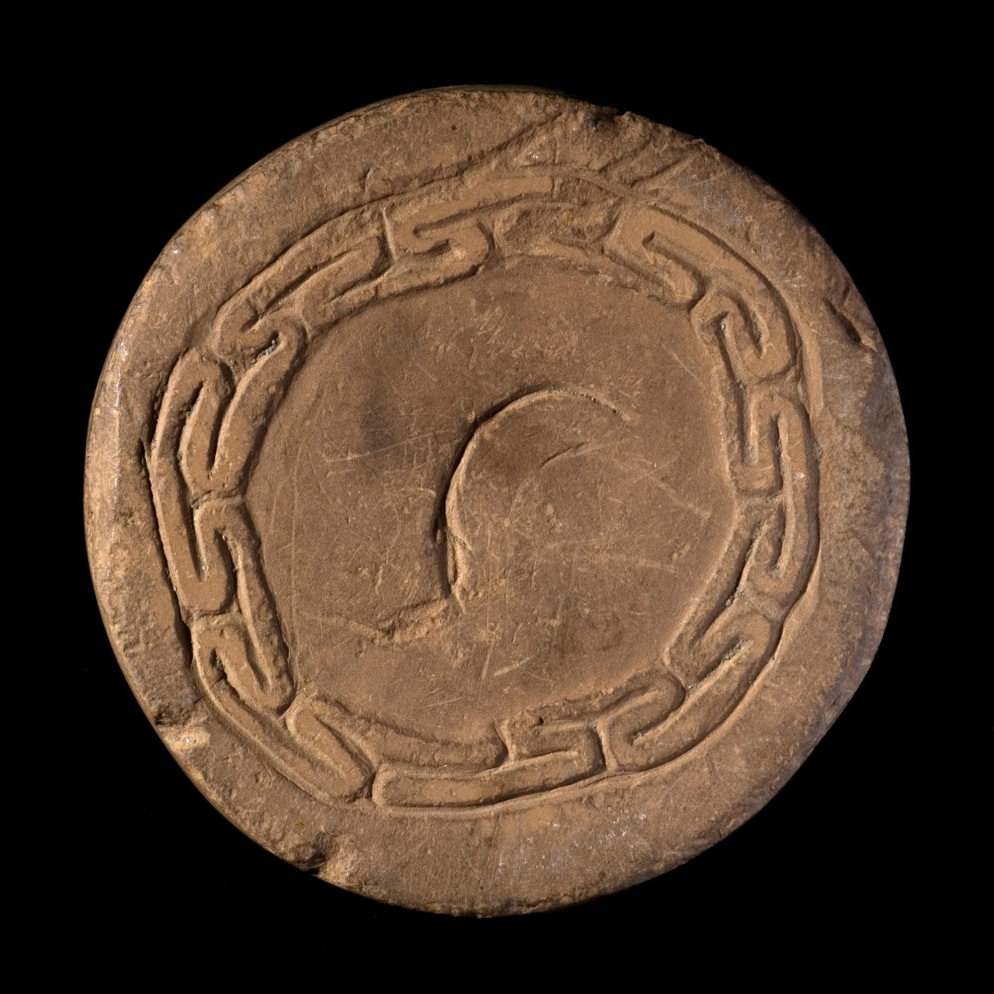 Image of Roundel of claystone, possibly a playing piece, with circular fret-like pattern, from Scatness © National Museums Scotland